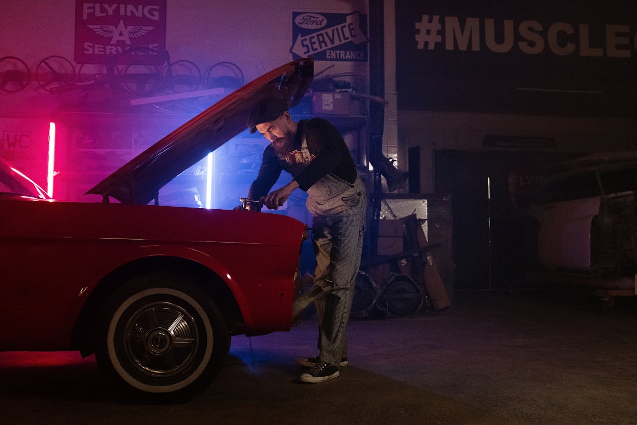 Mastering the First Impression: Your intriguing post title goes here A mechanic working on a vintage car in a garage with colorful neon lights.